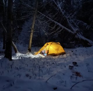 Glowing tent in the winter in Maine